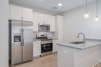 A modern kitchen with stainless steel appliances and white cabinets.